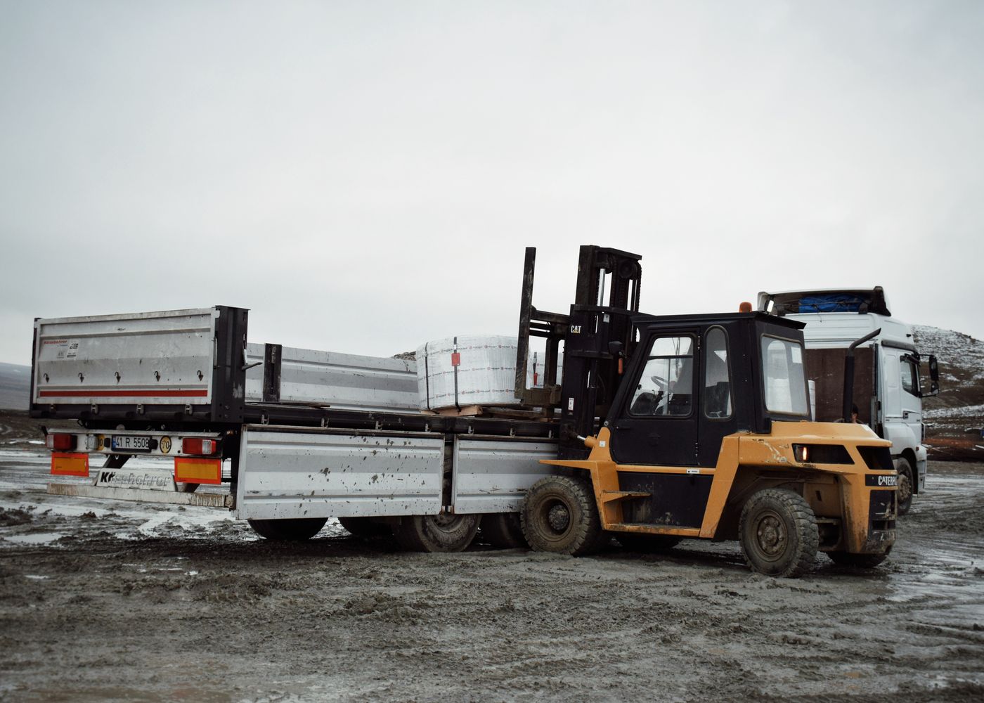 Cargo body selection: forklift loading truck. Illustrative stock photo.