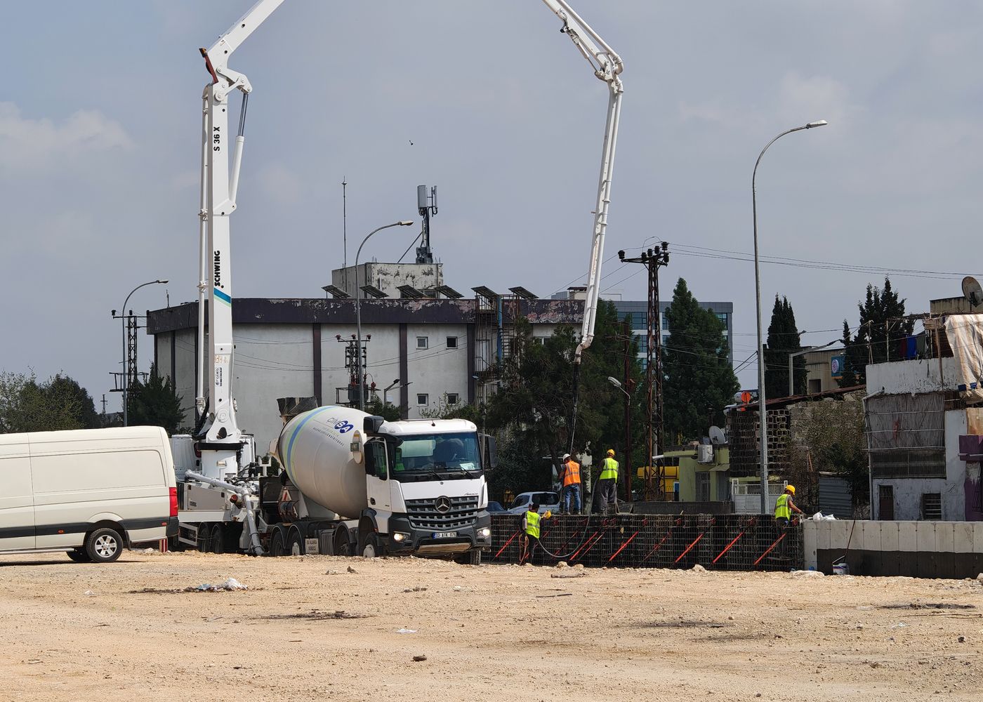 Concrete mixer inspection: mixer trucks at construction site. Illustrative stock photo.