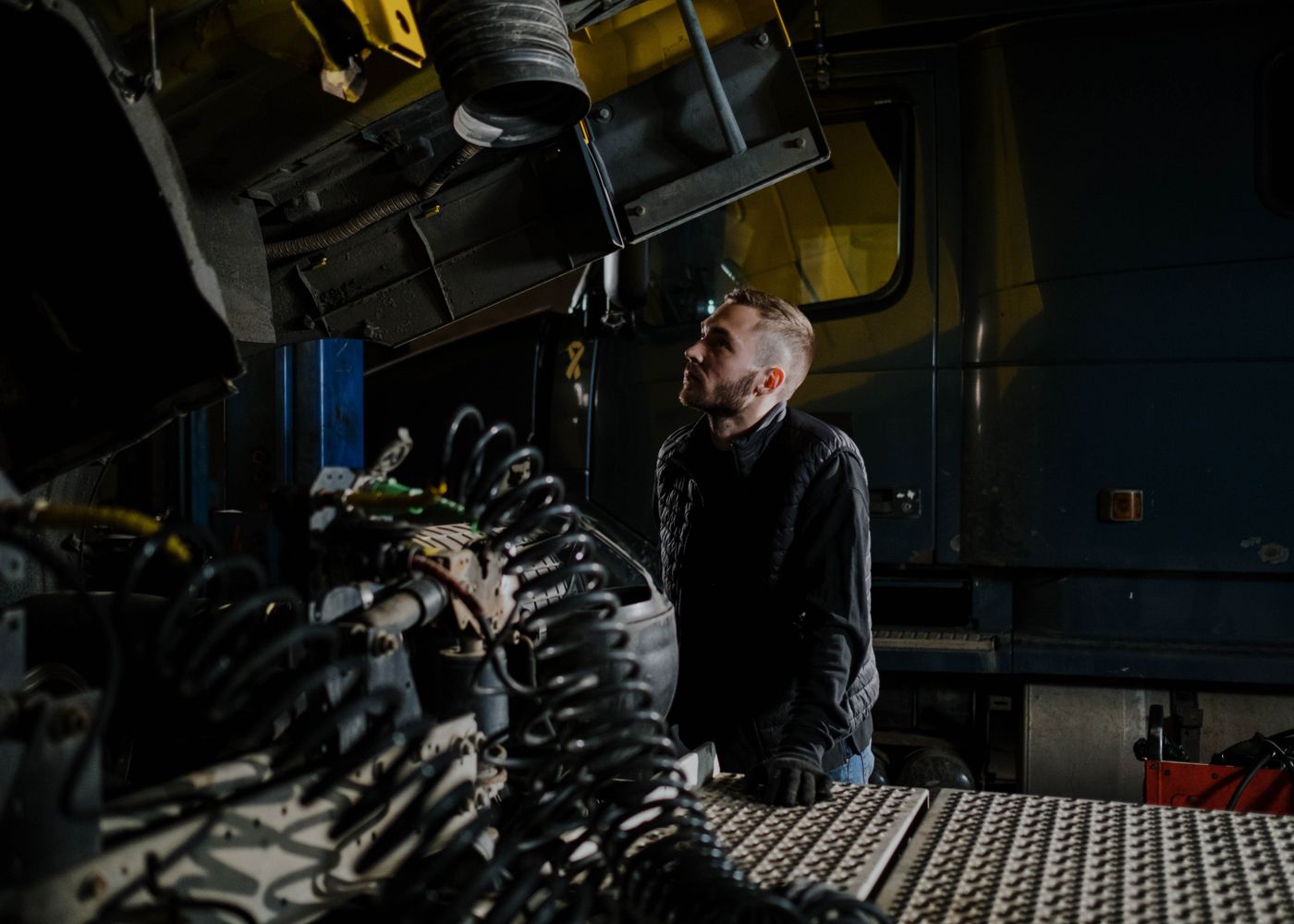 HOWO family guide: technician inspecting truck engine. Illustrative stock photo.